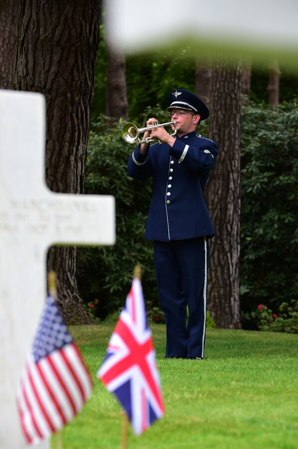 . U.S. Air Force Staff Sgt. Matthew Kirkpatrick, assigned to U.S. Air Forces in Europe and Africa Band, sounds Taps, during the Memorial Day ceremony at Brookwood American Military Cemetery, United Kingdom, May 24, 2015. The first American Service member burial was held May 1918, for members of the American Expeditionary Forces who lost their lives in Great Britain, the surrounding waters, from Influenza, and as a result of wounds suffered in France during World War I. (U.S. Air Force photo by Tech. Sgt. Chrissy Best/Released)