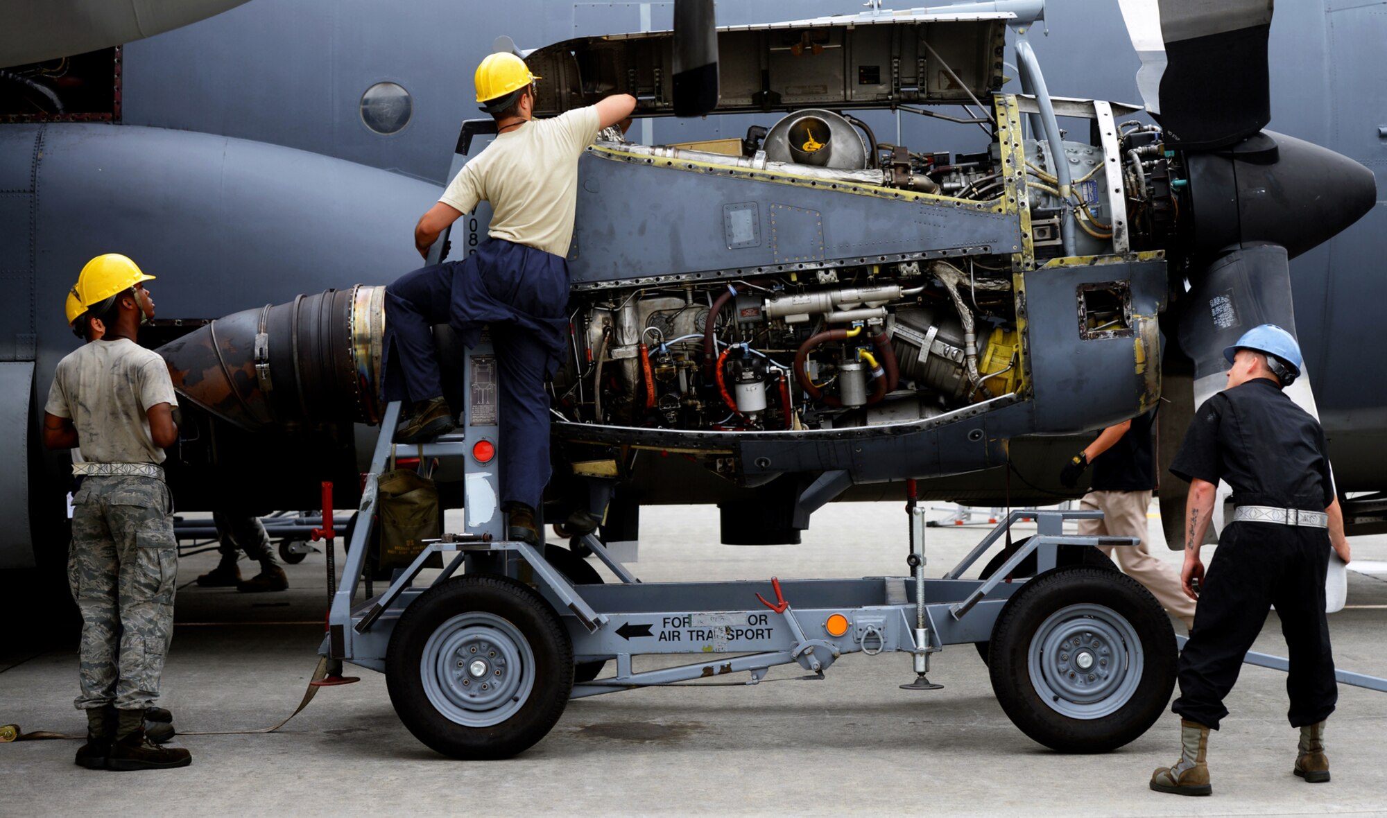 374th Maintenance Squadron Airmen prepare to extract an engine from a MC-130 Combat Talon II with a crane June 18, 2015, at Yokota Air Base, Japan. 374 MXS Airmen performed maintenance to ensure that the aircraft remains operational for its mission. (U.S. Air Force photo illustration by Airman 1st Class Delano Scott/Released)