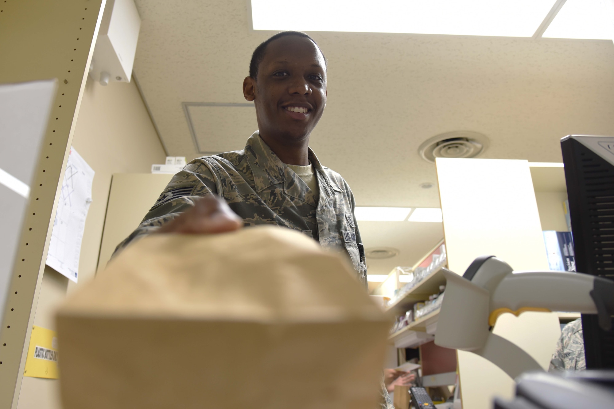 U.S. Air Force Staff Sgt. Marcus Hollins, NCO in charge of pharmacy support, hands a prescription to a patient at Misawa Air Base, Japan, June 17, 2015. After verifying a patient’s personal information, Hollins explains the proper use of the medication to the patient, ensuring the customer is fully informed of the prescriptions side-effects, dosage and intended usage. Misawa’s pharmacy team fills approximately 200 prescriptions daily, keeping Airmen and their families healthy. (U.S. Air Force photo by Senior Airman Patrick S. Ciccarone/Released)