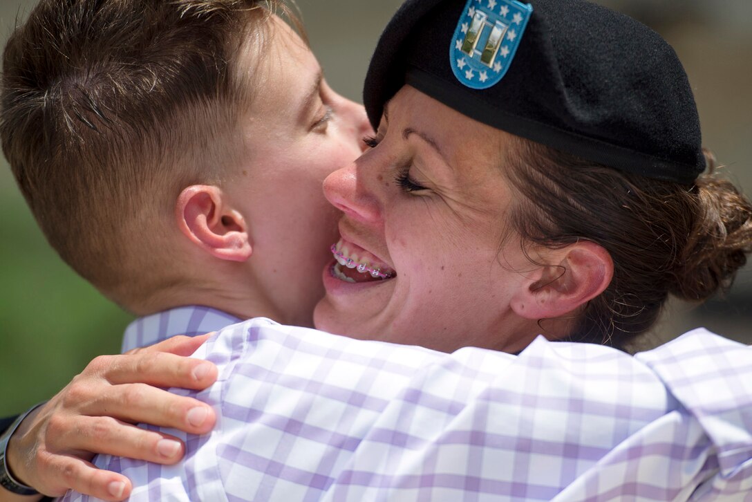 Army Capt. Kelly Elmlinger, front, hugs her best friend, Aaron Stewart, after Elmlinger’s promotion ceremony at the San Antonio Military Medical Center in San Antonio, Texas, June 12, 2015. Elmlinger is in remission from cancer and will transition from the Warrior Transition Battalion back to San Antonio Military Medical Center as a nurse administrator. DoD photo by EJ Hersom