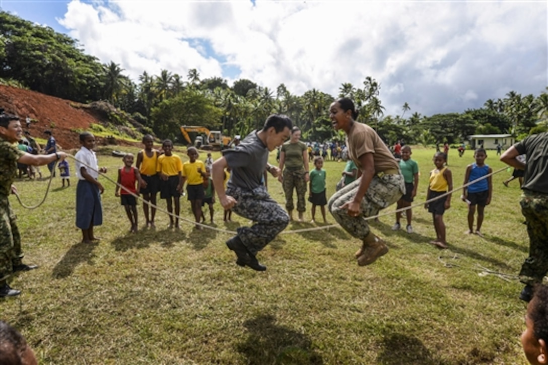 U.S. Navy Seaman Anaseini Taufa, right, and members of the Japan Self Defense Force jump rope in front of children from the Viani Primary School during Pacific Partnership 2015 in Vavua Levu, Fiji, June 17, 2015. The crew of the Military Sealift Command hospital ship USNS Mercy helped build a classroom at the school and celebrated with a ribbon-cutting ceremony.