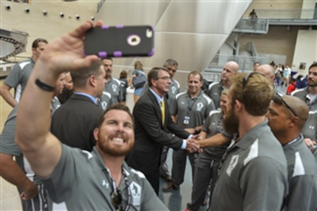 Members from the U.S. Special Operations Command team gather around Defense Secretary Ash Carter during a reception after the opening ceremony for the 2015 Department of Defense Warrior Games at the National Museum of the Marine Corps in Quantico, Va., June 19, 2015.