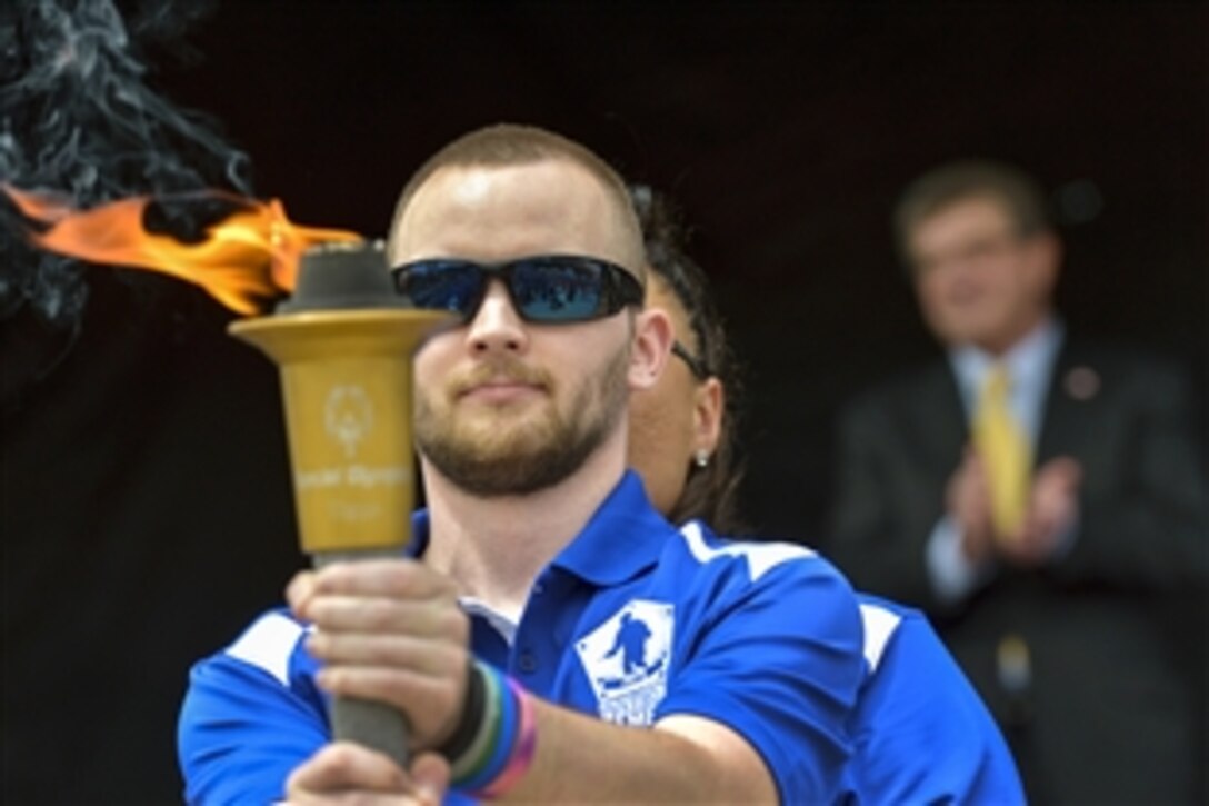 Representatives of military team athletes pass the ceremonial torch during the opening ceremony for the 2015 Department of Defense Warrior Games on Marine Corps Base Quantico, Va., June 19, 2015. 