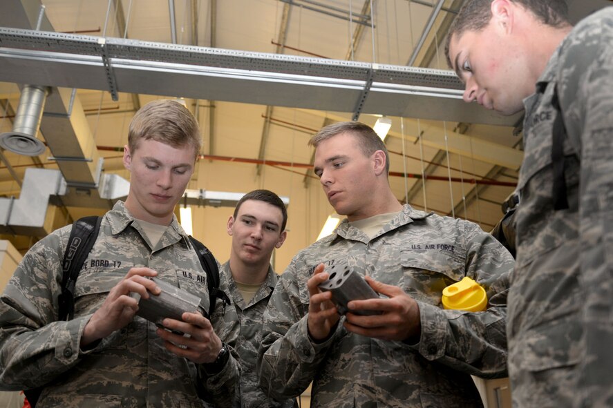 U.S. Air Force Academy cadets search for imperfections on aircraft parts during their tour of the 100th Maintenance Squadron non-destructive inspection section June 15, 2015, on RAF Mildenhall, England. The cadets spent two weeks on base learning about the operational Air Force before beginning their junior year of the USAFA to broaden their knowledge of their future careers, and give them firsthand experience with officers and enlisted personnel. (U.S. Air Force photo by Senior Airman Kate Thornton/Released)