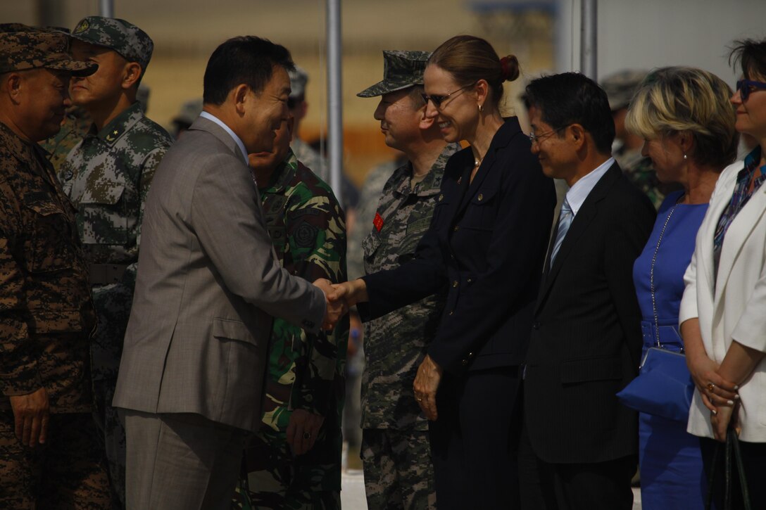 Tserendash Tsolmon, Minister of Defense of Mongolia, shakes hands with Piper Anne Wind Campbell, U.S. Ambassador to Mongolia, during the opening ceremonies of Exercise Khaan Quest 2015 at Five Hills Training Area in Tavantolgoi, Mongolia, June 20, 2015. Khaan Quest is a regularly scheduled, multinational exercise hosted annually by Mongolian Armed Forces and co-sponsored by U.S. Army, Pacific, and U.S. Marine Corps Forces, Pacific. KQ15 is the latest in a continuing series of exercises designed to promote regional peace and security. This year marks the 13th iteration of this training event.
