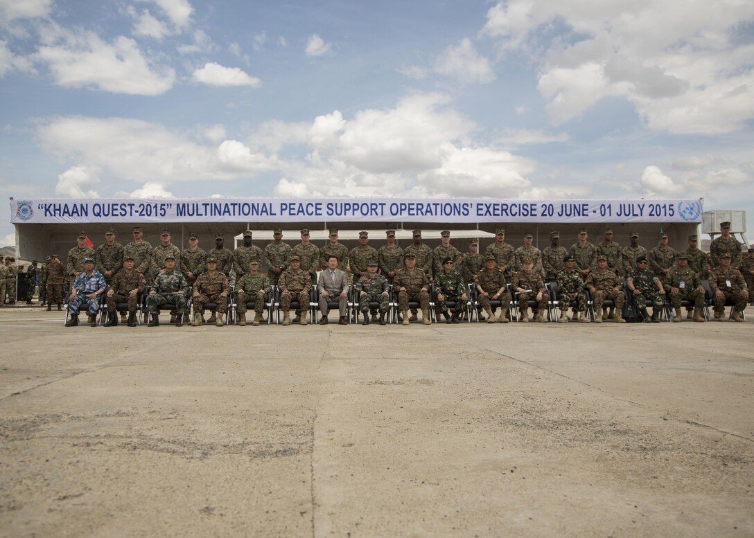U.S. Marines with 3rd Battalion, 2nd Marine Regiment pose for a group photo with a panel of distinguished visitors of participating nations during the opening ceremonies of Khaan Quest 2015, in Tavantolgoi, Mongolia, June 20, 2015. Khaan Quest is a regularly scheduled, multinational exercise hosted annually by Mongolian Armed Forces and co-sponsored by U.S. Army, Pacific, and U.S. Marine Corps Forces, Pacific. KQ15 is the latest in a continuing series of exercises designed to promote regional peace and security. This year marks the 13th iteration of this training event.