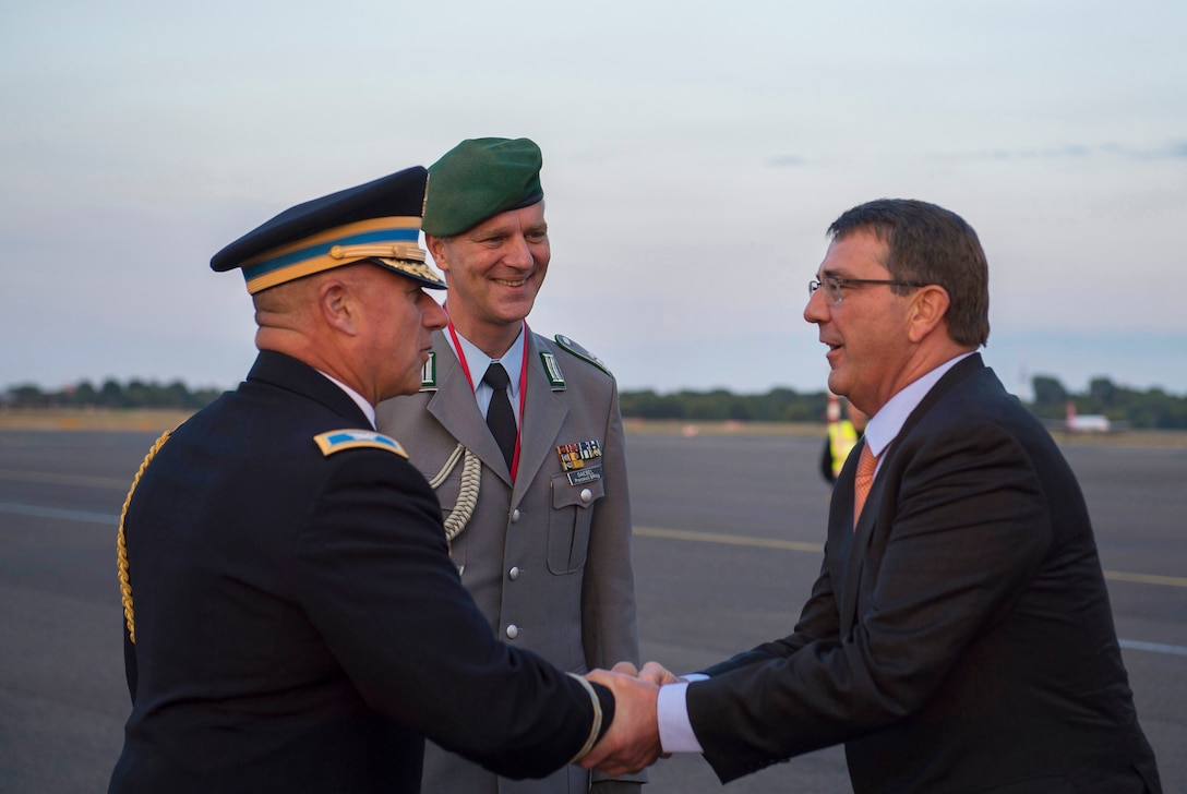 U.S. Defense Attaché to Germany Col. Greg Broecker greets U.S. Defense Secretary Ash Carter as he arrives in Berlin, June 21, 2015, while German Army Lt. Col. Frank Gaebel, center, a representative from the German Defense Ministry looks on. Carter plans to meet with European defense ministers and participate in his first NATO ministerial as defense secretary during the trip to Germany, Estonia and Belgium. 