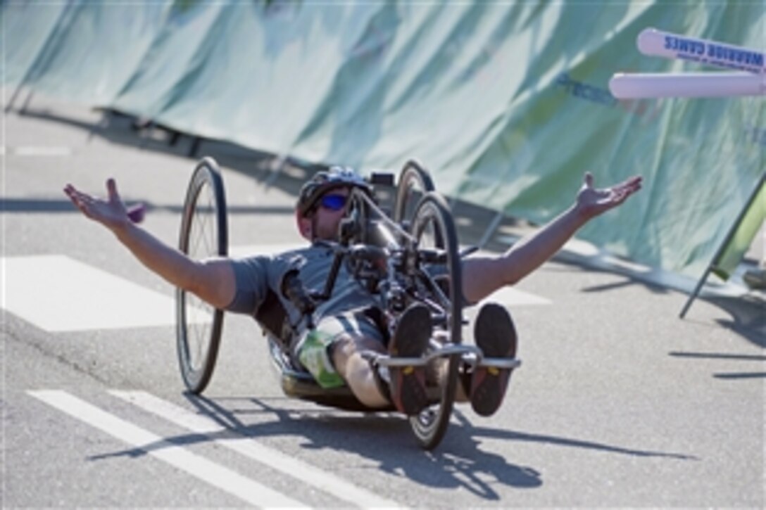 Team Special Operations Command's David Neumer crosses the finish line for gold in the men’s open hand cycle division during the 2015 Department of Defense Warrior Games on Marine Corps Base Quantico, Va., June 21, 2015.