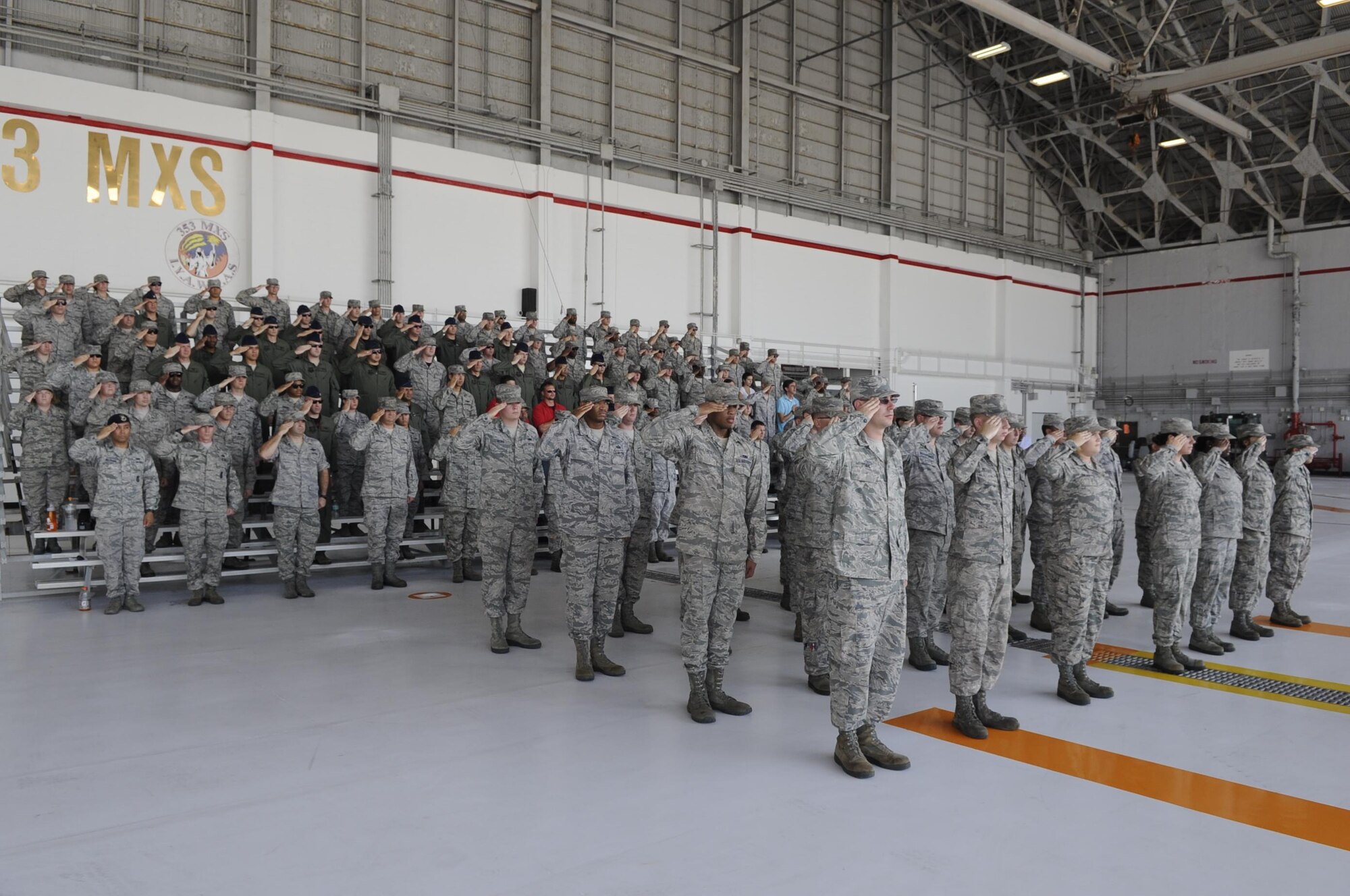 The Airmen from the 353rd Special Operations Maintenance Squadron salute during the playing of the American and Japanese National Anthems at a change of command ceremony on Kadena Air Base, Japan, June 19, 2015U.S.  Air Force Maj. Aaron Yager, newly appointed commander of the 353rd Special Operations Maintenance Squadron, comes from Headquarters United States Special Operations Command, MacDill Air Force Base, Florida, where he served as director fixed wing logistics and joint acquisitions team lead, directorate of logistics. (U.S. Air Force photo by Staff Sgt. Marcus Morris)