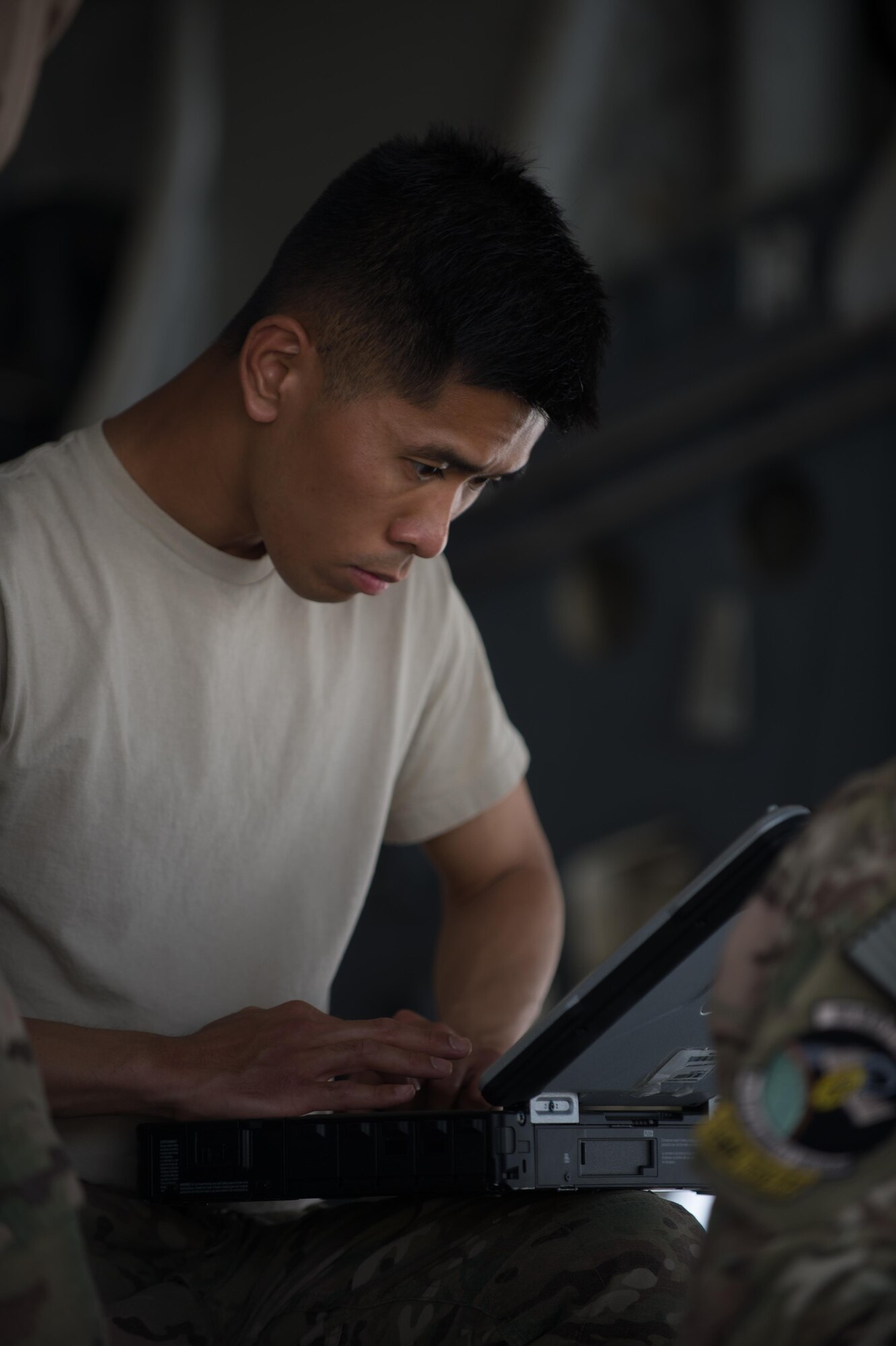 U.S. Air Force Senior Airman Steven Swei, 8th Expeditionary Air Mobility Squadron C-17 communications and navigation systems specialist, looks at technical orders on a laptop while working to repair a C-17 Globemaster III aircraft at Bagram Airfield, Afghanistan, June 19, 2015. 8th EAMS provide the C-5 and C-17 maintenance needed to keep the strategic airlift mission in Afghanistan going. (U.S. Air Force photo by Tech. Sgt. Joseph Swafford/Released)