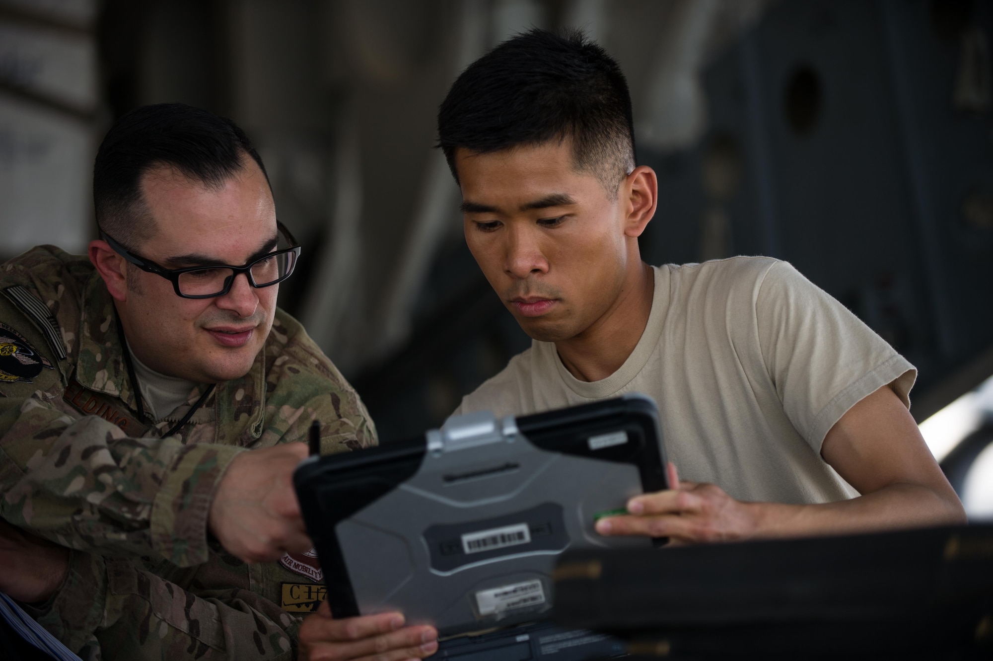 U.S. Air Force Master Sgt. Doug Fielding, left, and Senior Airman Steven Swei both assigned to the 8th Expeditionary Air Mobility Squadron looks at technical orders on a laptop while working to repair a C-17 Globemaster III aircraft at Bagram Airfield, Afghanistan, June 19, 2015. 8th EAMS provide the C-5 and C-17 maintenance needed to keep the strategic airlift mission in Afghanistan going. (U.S. Air Force photo by Tech. Sgt. Joseph Swafford/Released)