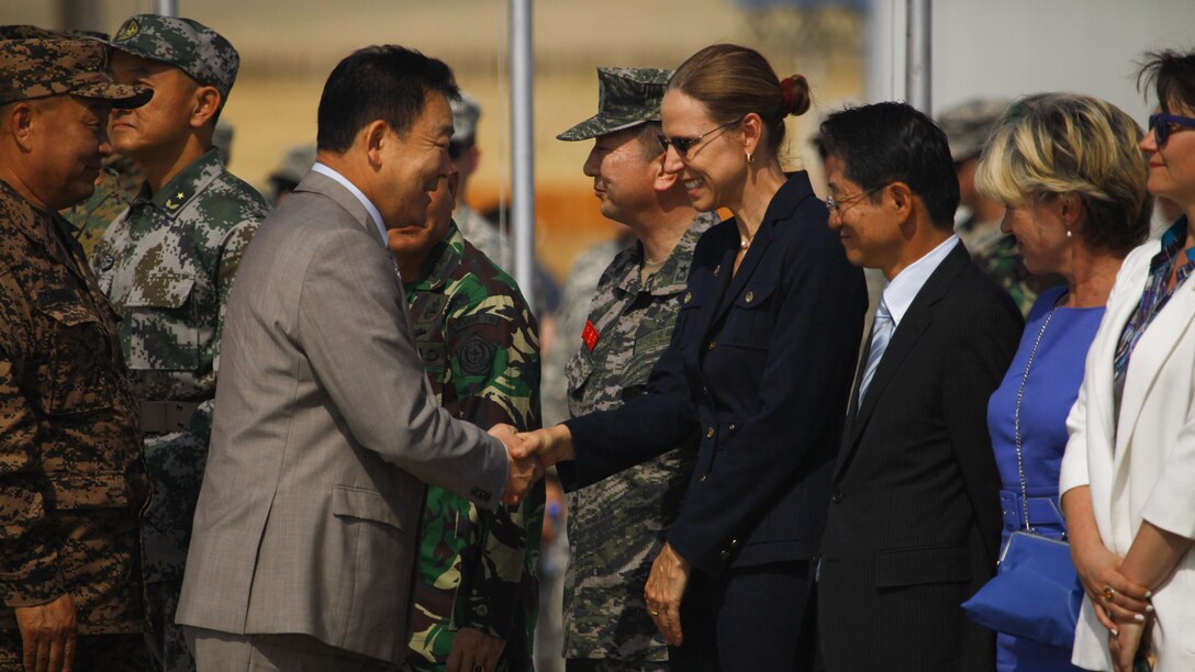 Tserendash Tsolmon, Minister of Defense of Mongolia, shakes hands with Piper Anne Wind Campbell, U.S. Ambassador to Mongolia, during the opening ceremonies of Exercise Khaan Quest 2015 at Five Hills Training Area in Ulaanbaatar, Mongolia, June 20, 2015. Khaan Quest is a regularly scheduled, multinational exercise hosted annually by Mongolian Armed Forces and co-sponsored by U.S. Army, Pacific, and U.S. Marine Corps Forces, Pacific. KQ15 is the latest in a continuing series of exercises designed to promote regional peace and security. This year marks the 13th iteration of this training event. 