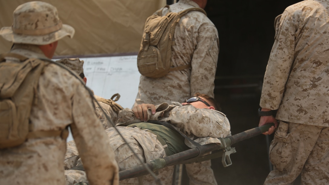 Marines with 4th Medical Battalion, 4th Marine Logistics Group, Marine Forces Reserve, carry a casualty in a mass heat casualty exercise during the 4-15 Integrated Training Exercise aboard Marine Corps Air Ground Combat Center, Calif., June 20, 2015. During the mass heat casualty exercise, Marines and sailors faced a situation where multiple casualties were rapidly brought into the medical station, and Marines and Sailors had to work together efficiently to ensure that all casualties were assessed and treated properly. 