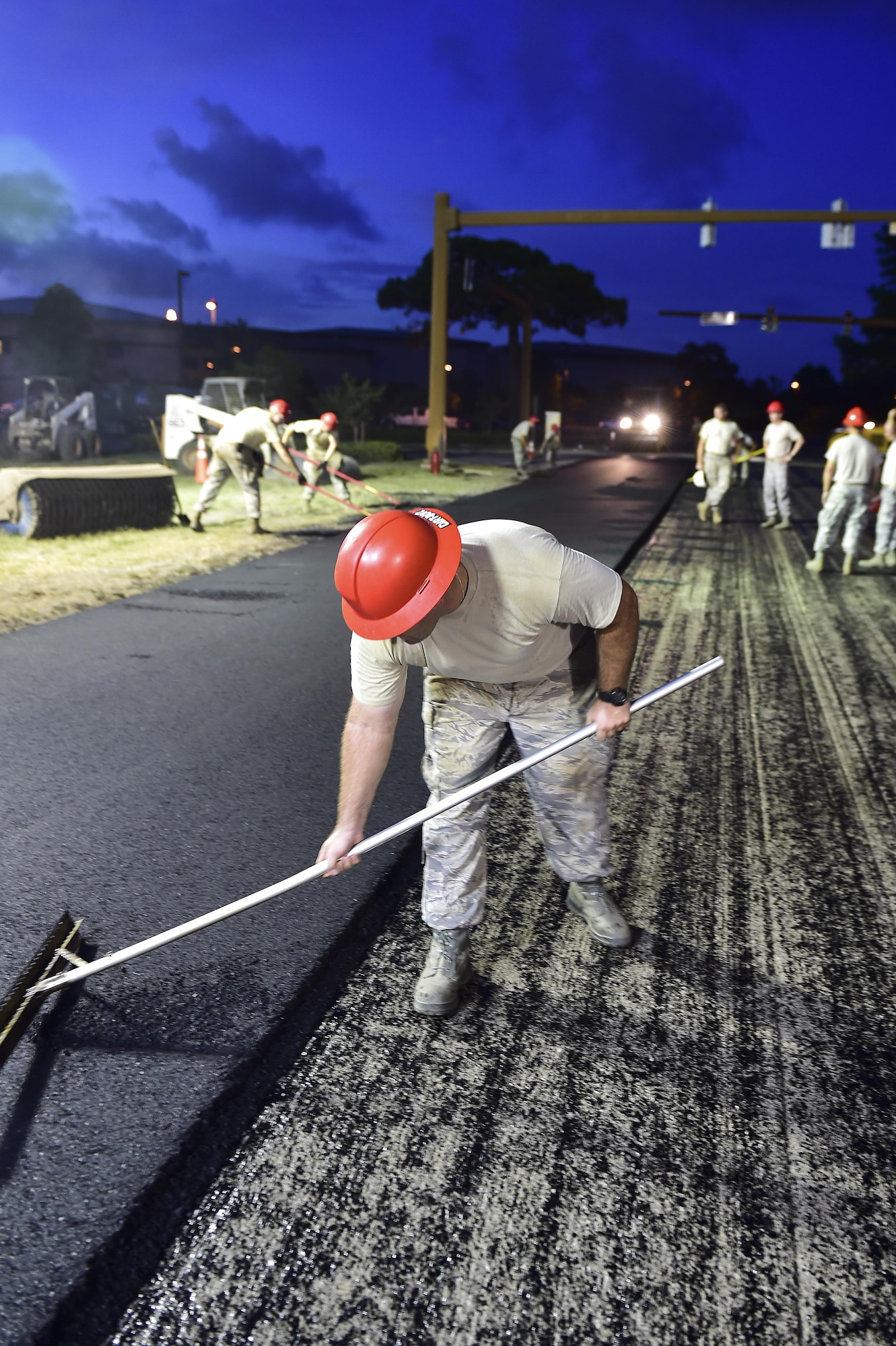 Tech Sgt. Matthew Mayfield, 823rd RED HORSE Squadron planning NCO in-charge, fills in holes left from measuring the depth of the asphalt during a road re-construction project of Independence Road at Hurlburt Field, Fl., June 16, 2015. The re-construction project repaired multiple pot holes and cracks caused by pooling water. (U.S. Air Force photo/Senior Airman Jeff Parkinson)