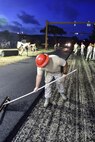 Tech Sgt. Matthew Mayfield, 823rd RED HORSE Squadron planning NCO in-charge, fills in holes left from measuring the depth of the asphalt during a road re-construction project of Independence Road at Hurlburt Field, Fl., June 16, 2015. The re-construction project repaired multiple pot holes and cracks caused by pooling water. (U.S. Air Force photo/Senior Airman Jeff Parkinson)