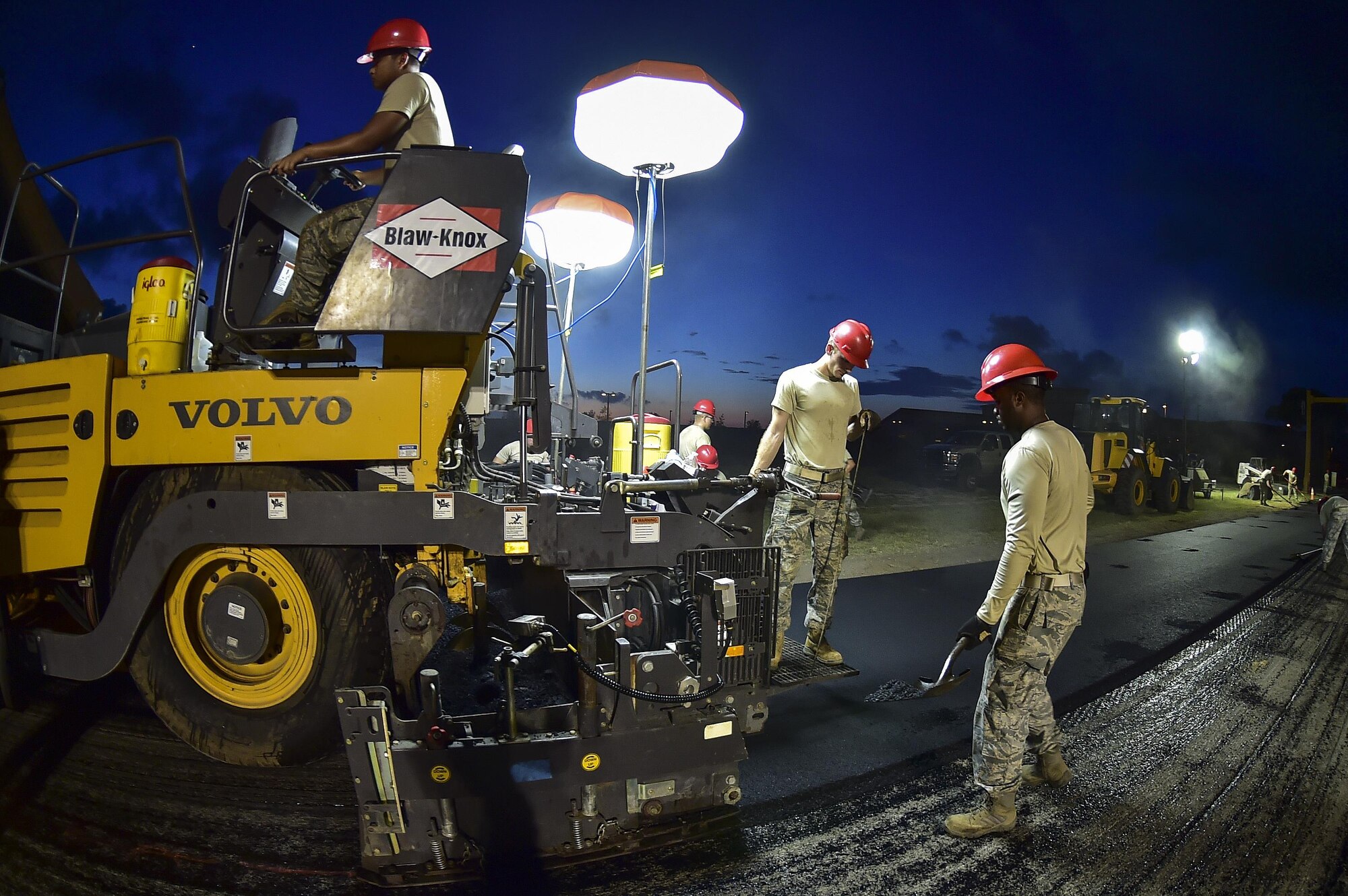 Airmen from the 823rd RED HORSE Squadron lay asphalt during a road re-construction project on Independence Road at Hurlburt Field, Fl., June 16, 2015. The re-construction project repaired multiple pot holes and cracks caused by pooling water. (U.S. Air Force photo/Senior Airman Jeff Parkinson)