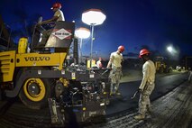 Airmen from the 823rd RED HORSE Squadron lay asphalt during a road re-construction project on Independence Road at Hurlburt Field, Fl., June 16, 2015. The re-construction project repaired multiple pot holes and cracks caused by pooling water. (U.S. Air Force photo/Senior Airman Jeff Parkinson)
