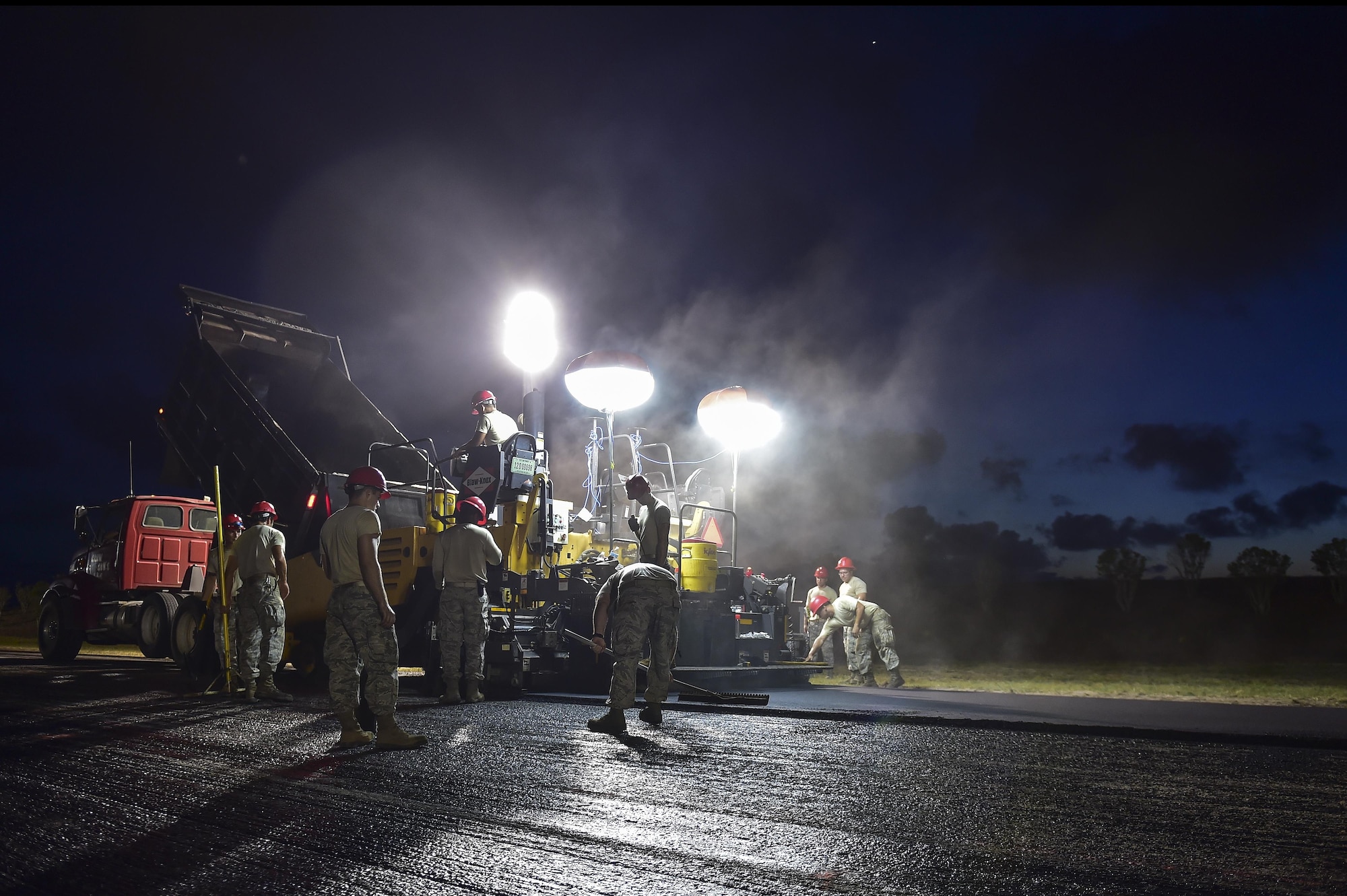 Airmen from the 823rd RED HORSE Squadron lay asphalt during a road re-construction project on Independence Road at Hurlburt Field, Fl., June 16, 2015. The re-construction project repaired multiple pot holes and cracks caused by pooling water. (U.S. Air Force photo/Senior Airman Jeff Parkinson)