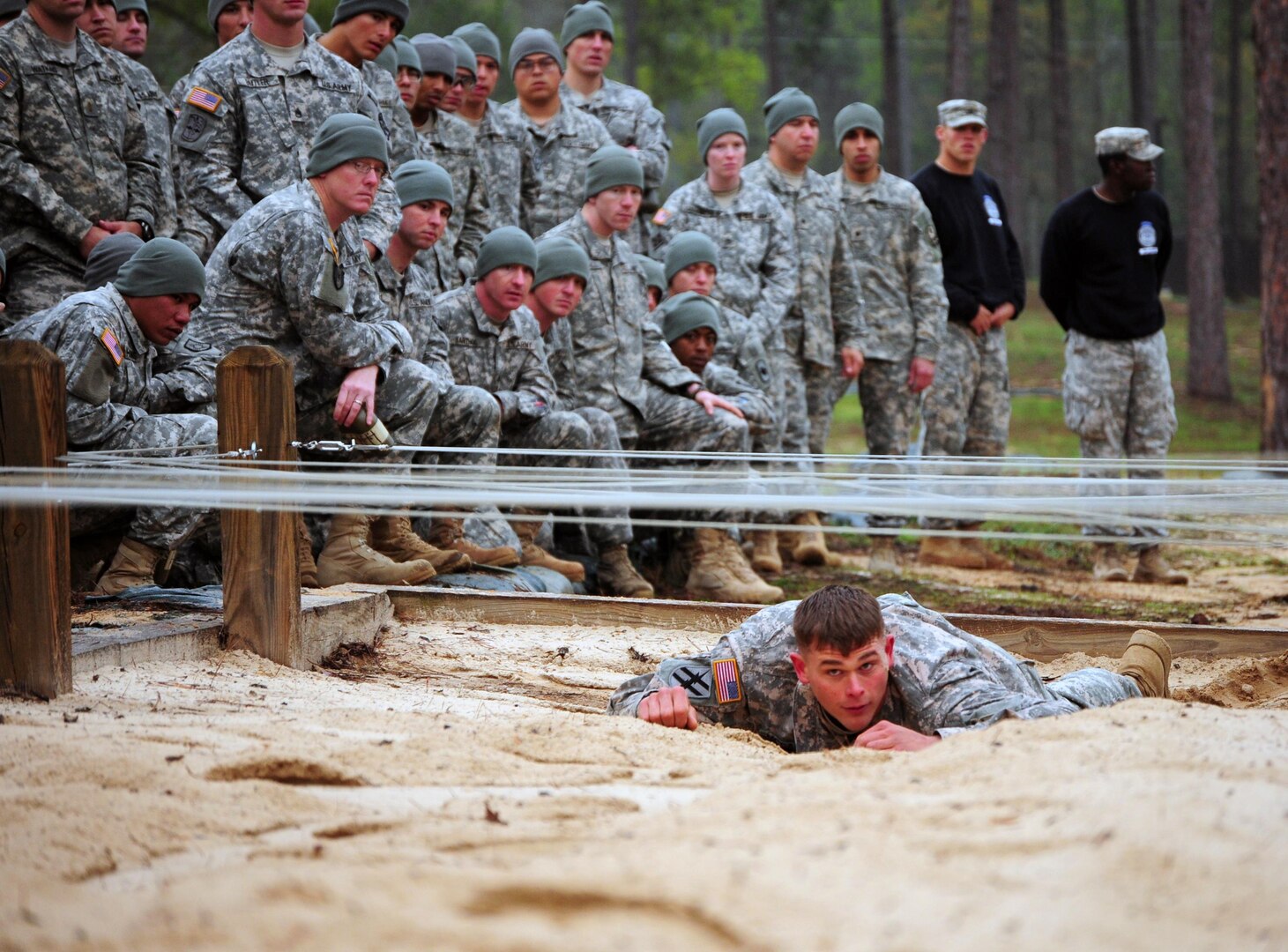 Army Cpt. Roswell McLarin of Fort Benning's Warrior Training Center demonstrates the low crawl to prospective students March 29,2011. (U.S. Army photo by Alexandra Hemmerly-Brown)