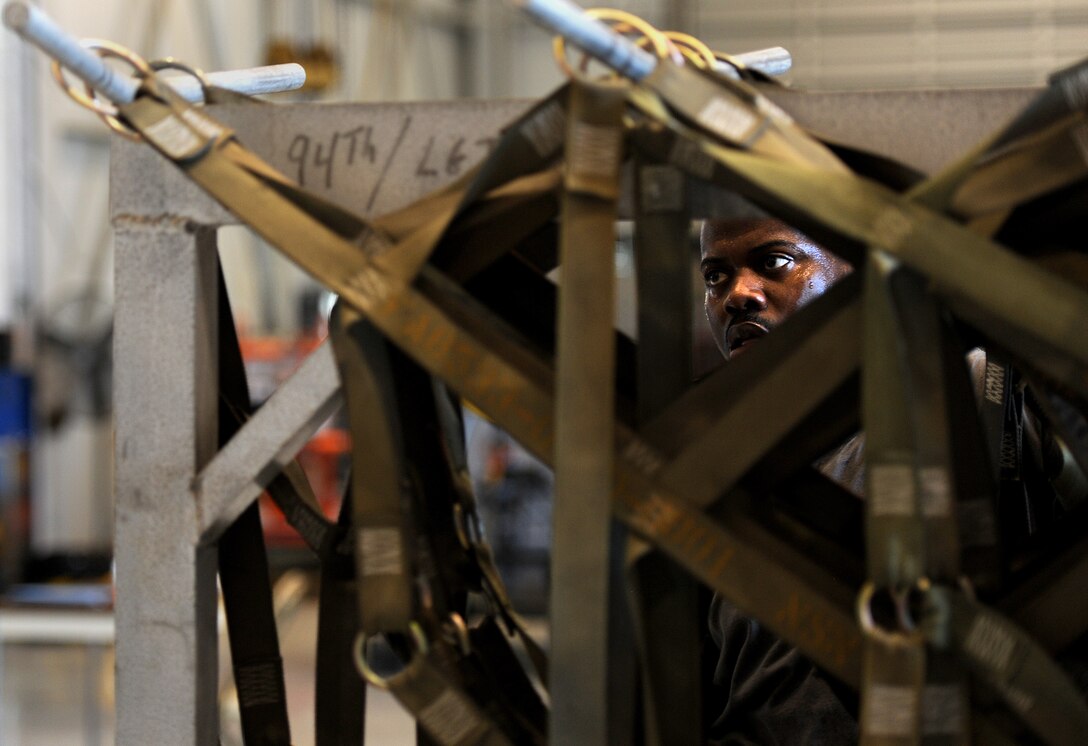 U.S. Air Force Tech. Sgt. Nathanial Terrell, 86th Aerial Port Squadron, hangs up side nets during the Pallet Build-Up competition during the Port Dawg Challenge at Dobbins Air Reserve Base, Ga., June 18, 2015. The Port Dawg Challenge was created to enhance and maintain the camaraderie, esprit de corps and prestige of Aerial Port Airmen while promoting professionalism, leadership, training and communication between "Port Dawgs." (U.S. Air Force photo by Tech. Sgt. Stephen D. Schester/Released)