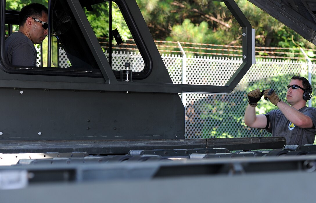 U.S. Air Force Tech. Sgts. Robert Adams, left and Michael Mellein, both assigned to the 86th Aerial Port Squadron, work together in guiding a 25K Halverson during the Port Dawg Challenge at Dobbins Air Reserve Base, Ga., June 18, 2015. The Port Dawg Challenge was created to enhance and maintain the camaraderie, esprit de corps and prestige of Aerial Port Airmen while promoting professionalism, leadership, training and communication between "Port Dawgs." (U.S. Air Force photo by Tech. Sgt. Stephen D. Schester/Released)