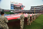 Members of the D.C. National Guard hold a football-field sized American flag on the outfield during pre-game ceremonies for Opening Day at Nationals Park in Washington, D.C. March 31, 2011.