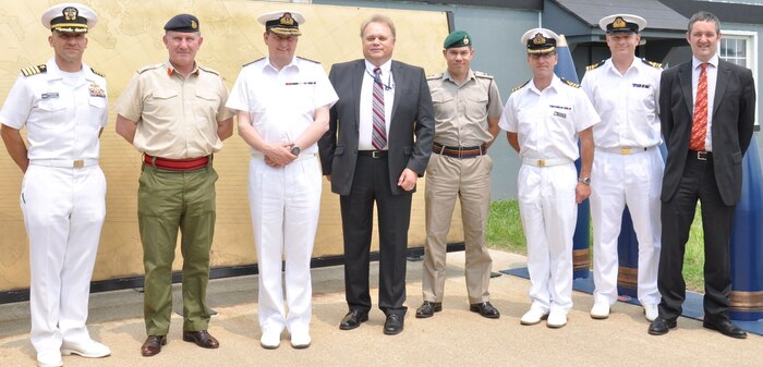 Naval Surface Warfare Center Dahlgren Division (NSWCDD) and British military officials pause in front of the Potomac River Test Range metal map during the UK delegation's tour June 10. Dahlgren scientists and engineers briefed the delegation on the command's testing facilities and technologies ranging from the electromagnetic railgun to the hypervelocity projectile. Briefings on directed energy programs included a high energy laser demonstration. "NSWCDD has a rich history of collaboration with the UK that includes many topics from short term tasks all the way to a missile agreement established in 1963 that we continue to support here today," said Jed Ryan,  NSWCDD International Partnering Office lead. "Working together with our allies during the science and technology as well as the RDT&E (research, development, test and evaluation) phases can lead to many benefits such as program improvements, cost and time savings plus enhanced interoperability."  Standing (l. to r.) are NSWCDD Commanding Officer Capt. Brian Durant; UK Defense Attaché to the US, Maj. Gen. Richard Cripwell; UK Royal Navy Second Sea Lord Vice Adm. Jonathan Woodcock; Ryan; Lt Col. Carl Harris, staff officer to second sea lord; Cmdr. Ned Kelly, UK assistant naval attaché to the US; Lt. Cmdr.  Mick Deakin, Personnel Exchange Program U.K. naval officer assigned to NSWCDD; and Steve Waterworth, British defense staff officer.  