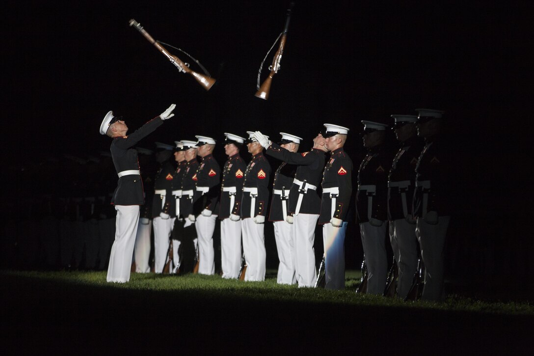 Members of the Marine Corps Silent Drill Platoon perform during the evening parade at Marine Barracks Washington, D.C., June 19, 2015. Retired U.S. Marine Corps Lt. Gen. Robert M. Shea, chairman of the Board of Directors, Marine Corps Toys for Tots Foundation, was the guest of honor for the parade and Lt. Gen. Richard P. Mills, commander, Marine Forces Reserve and Marine Forces North, was the hosting official for that same parade. The Evening Parade summer tradition began in 1934 and features the Silent Drill Platoon, the U.S. Marine Band, the U.S. Marine Drum and Bugle Corps and two marching companies. More than 3,500 guests attend the parade every week. (U.S. Marine Corps Photo by Lance Cpl. Hailey D. Stuart/Released)
