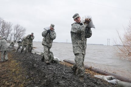 From right to left: Army Spc. Eric Wiederholt, Army Spc. Joshua Lanzdorf and
Army Spc. Randy Birchfield, all of the 815th Engineer Company, Detachment 2,
based in Lisbon, N.D., carry sandbags in the rain along a flood levee for
placement in a flood barrier April 10, 2011, at a rural farmstead in Cass
County, N.D. The Soldiers are members of a North Dakota National Guard quick
response force team that has been sent to the rural home, which has been
surrounded by miles of floodwater, by the Cass County tactical operations
center. About 500 Guardsmen are currently conducting flood operations in
North Dakota, with the vast majority in Cass County.