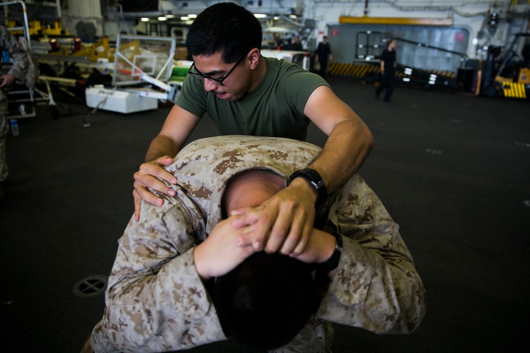 U.S. Marines with Lima Company, Battalion Landing Team 3rd Battalion, 1st Marine Regiment, 15th Marine Expeditionary Unit, practice detainee-handling techniques aboard the USS Essex (LHD 2) in the Indian Ocean, June 19, 2015. The Marines practiced controlling the potential threat and thoroughly searching them for weapons or other items. (U.S. Marine Corps photo by Cpl. Anna Albrecht/Released)