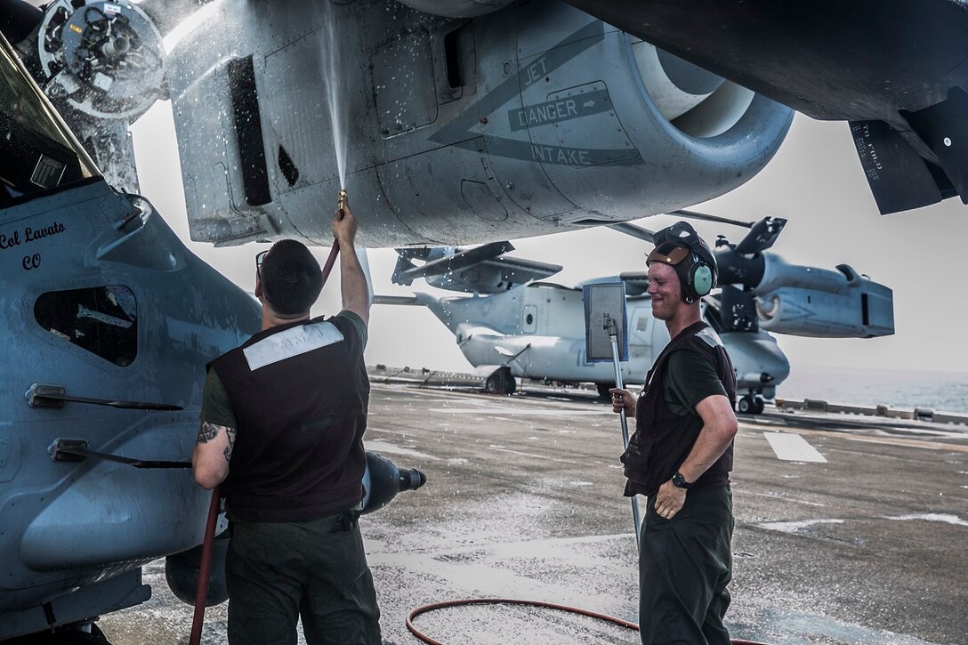 U.S. Marines with Marine Medium Tiltrotor Squadron 161 (Reinforced), 15th Marine Expeditionary Unit, wash an MV-22B Osprey on the flight deck of the USS Essex (LHD 2) in the Indian Ocean, June 20, 2015. These Marines wash the aircraft once a week to ensure they stay in good condition and are ready to fly  at a moment’s notice. (U.S. Marine Corps photo by Cpl. Anna Albrecht/Released)