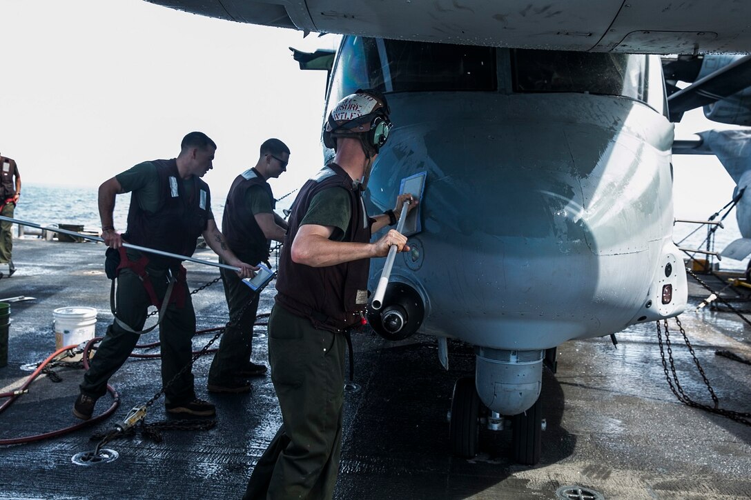U.S. Marines with Marine Medium Tiltrotor Squadron 161 (Reinforced), 15th Marine Expeditionary Unit, wash an MV-22B Osprey on the flight deck of the USS Essex (LHD 2) in the Indian Ocean, June 20, 2015. These Marines wash the aircraft once a week to ensure they stay in good condition and are ready to fly at a moment’s notice. (U.S. Marine Corps photo by Cpl. Anna Albrecht/Released)