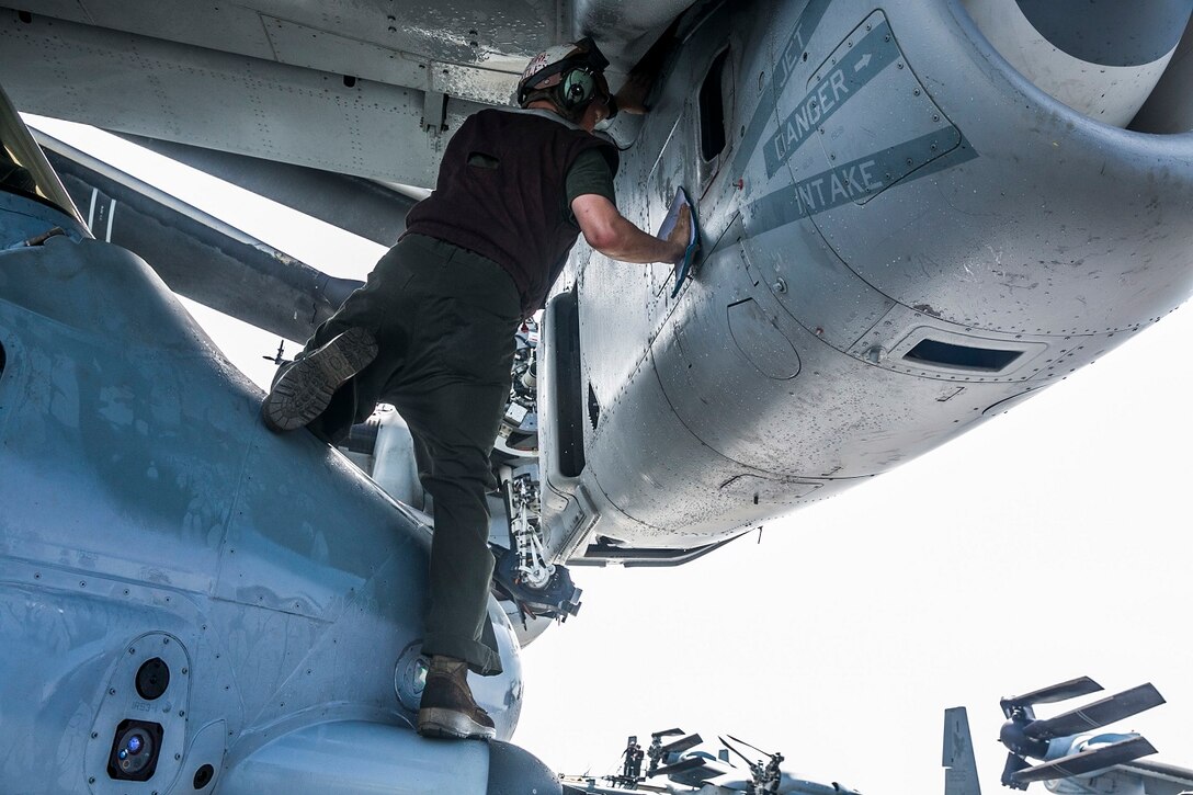 U.S. Marine Cpl. Miles Losurehuntley washes an MV-22B Osprey on the flight deck aboard the USS Essex (LHD 2) in the Indian Ocean, June 20, 2015. Losurehuntley is a flight line mechanic with Marine Medium Tiltrotor Squadron 161 (Reinforced), 15th Marine Expeditionary Unit. These Marines keep their aircraft clean to ensure they are in the best condition possible and are able to fly at a moment’s notice. (U.S. Marine Corps photo by Cpl. Anna Albrecht/Released)