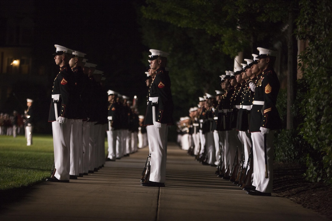 Marines with Marine Barracks Washington D.C. perform during the evening parade, June 19, 2015. Retired U.S. Marine Corps Lt. Gen. Robert M. Shea, chairman of the Board of Directors, Marine Corps Toys for Tots Foundation, was the guest of honor for the parade and Lt. Gen. Richard P. Mills, commander, Marine Forces Reserve and Marine Forces North, was the hosting official for that same parade. The Evening Parade summer tradition began in 1934 and features the Silent Drill Platoon, the U.S. Marine Band, the U.S. Marine Drum and Bugle Corps and two marching companies. More than 3,500 guests attend the parade every week. (U.S. Marine Corps Photo by Lance Cpl. Hailey D. Stuart/Released)
