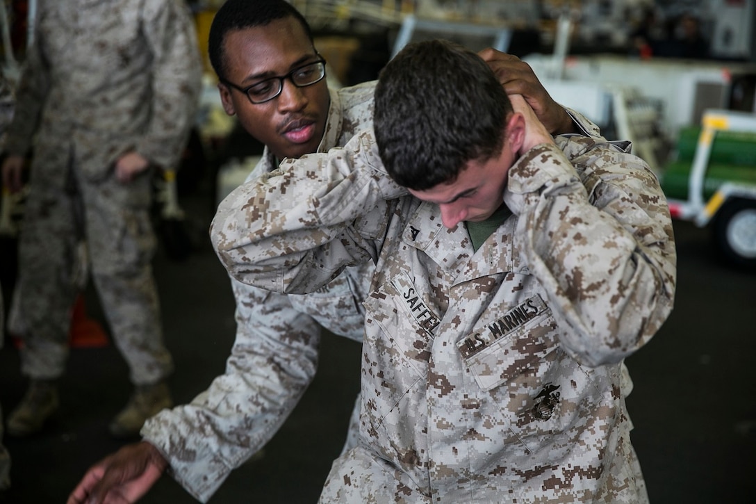 U.S. Marine Lance Cpl. Tiandre Sabur, left, practices searching Lance Cpl. Joshua Saffell aboard the USS Essex (LHD 2) in the Indian Ocean, June 19, 2015. Sabur and Saffell are motormen with Lima Company, Battalion Landing Team 3rd Battalion, 1st Marine Regiment, 15th Marine Expeditionary Unit. These Marines practiced conducting thorough searches on suspected threats. (U.S. Marine Corps photo by Cpl. Anna Albrecht/Released)