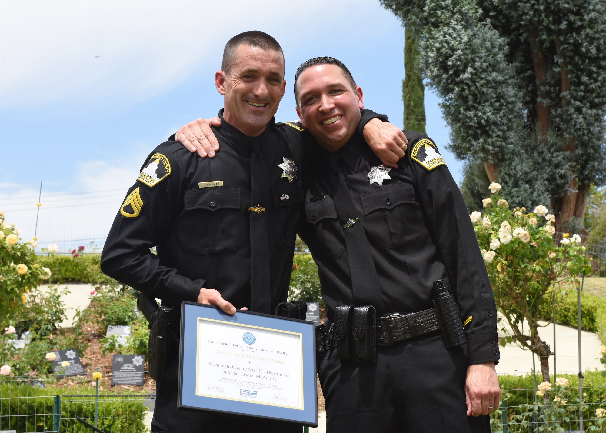 Staff Sgt. Erskine Reed, Beale Air Force Base reservist and Sacramento County deputy sheriff, and his long time supervisor, Sgt. Daniel McAuliffe, hold one of the two awards given to McAuliffe for his excellent supervision of Reed at a ceremony at the Sheriff's Training Academy in Sacramento, Calif., June 17. Reed, a long time sheriff and new reservist, nominated McAuliffe to receive two Employer Support of the Guard and Reserve awards for his support of Reed's military career. For a successful military career, it's vital for reservists to have the support and understanding of their civilian employers, especially when flexible schedules and absences may be required to accommodate military service. (U.S. Air Force photo by Tech. Sgt. Heather Skinkle/Released) 