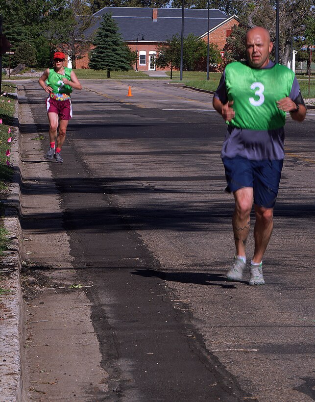 Dave Sorrels and Lisa Spillman near the finish-line of the 90th Force Support Squadron’s 23rd Annual Mini-Triathlon June 20, 2015.After swimming 500 meters and biking 10-kilometers, participants had to complete a 5k run. (U.S. Air Force photo by Airman 1st Class Brandon Valle)