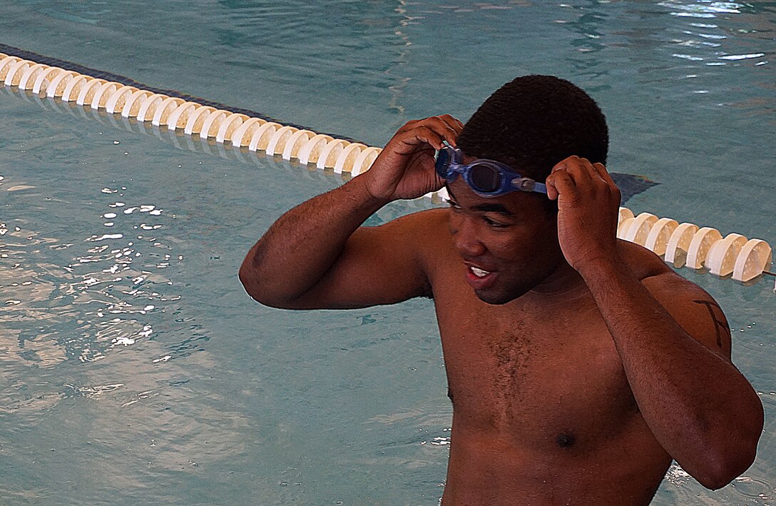 Tyree Wright pulls on his goggles before starting a 500-meter swim at the F.E. Warren Air Force Base, Wyo., Aquatics Center June 20, 2015. The swim was the first leg of the 90th Force Support Squadron mini-triathlon. (U.S. Air Force photo by Airman 1st Class Brandon Valle)
