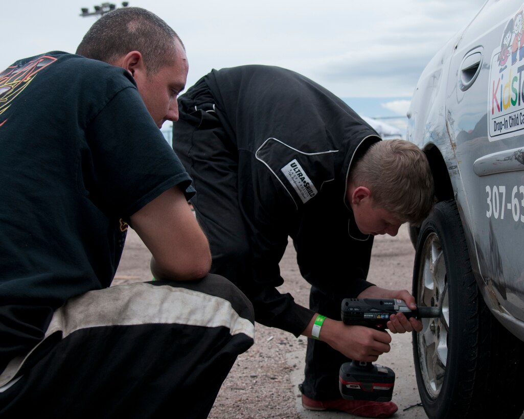 Maj. Neil Copenhaver, 20th Air Force deputy director of logistics, and his son, Jeron Schmidt, 13, replace a tire on Schmidt’s stock car June 13, 2015, in Cheyenne, Wyo. Copenhaver is teaching Schmidt the ins and outs of stock car racing using the knowledge acquired from his time in racing leagues. (U.S. Air Force photo by Airman 1st Class Malcolm Mayfield)