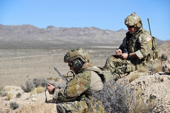 Master Sgt. Jared Pietras, left, U.S. Air Force Weapons School, joint terminal attack controller advanced course instructor and Tech. Sgt. James Larsen, JTAC, advanced instructor course, student pass target coordinates to an AH-64D Apache helicopters on the Nevada Test and Training Range, Oct. 9, 2014.    The USAFWS teaches graduate-level instructor courses that provide the world's most advanced training in weapons and tactics employment. (U.S. Air Force photo by Susan Garcia) 

