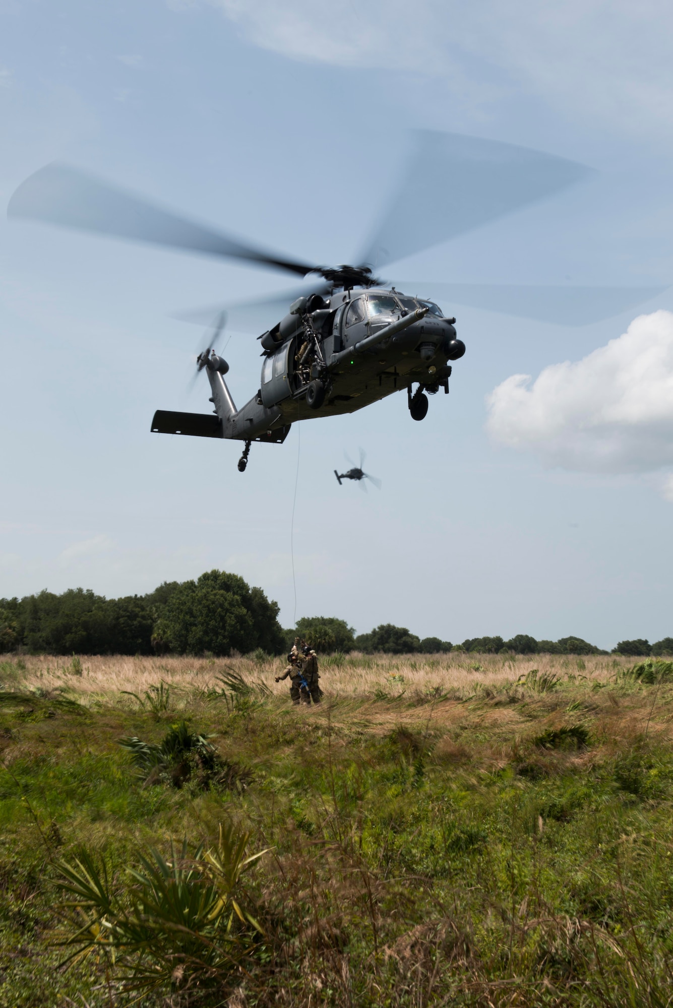 Pararescuemen from the 920th Rescue Wing, Patrick Air Force Base, Fla., climb onto a rope before being hoisted into an HH-60G Pave Hawk during a simulated personnel recovery scenario for Exercise DRAGON STRIKE June 11, 2015, near Avon Park Air Force Range, Fla. The scenario focused on communication between pilots and injured personnel and effective aircraft signaling to locate them. (U.S. Air Force photo by Airman 1st Class Dillian Bamman/Released)