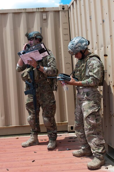 U.S. Air Force Staff Sgt. Robert Cooch, left, 18th Air Support Operations Group joint terminal attack controller, speaks with Staff Sgt. Rodshede Roberts, 820th Combat Operations Squadron technologies NCO, and A-10C Thunderbolt II pilots during Exercise DRAGON STRIKE June 9, 2015, at Avon Park Air Force Range, Fla. Roberts piloted an RQ-11B Raven, a small unmanned aerial vehicle, during the scenario to help Cooch locate simulated threats and describe their location to the A-10 pilots. (U.S. Air Force photo by Airman 1st Class Dillian Bamman/Released)