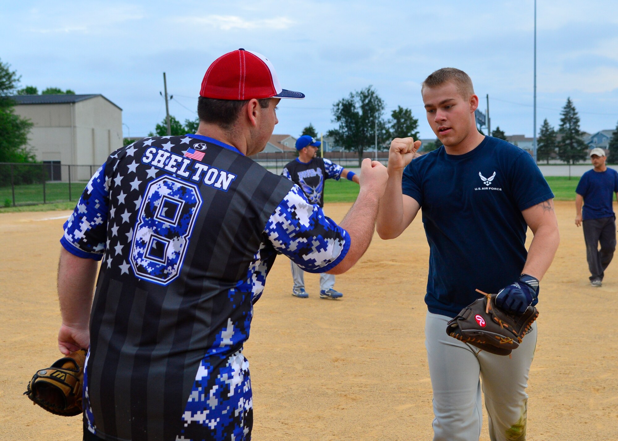 Brandon Shelton, 436th Security Force Squadron, left, bumps fists with Tyler Evans, 436th SFS, right, at the end of the second inning in an intramural softball game June 17, 2015, at the softball field on Dover Air Force Base, Del. Evans is one of the newest players to the 436th SFS team and hit the only homerun for his team against the 373d Training Squadron. (U.S. Air Force photo/Airman 1st Class William Johnson)