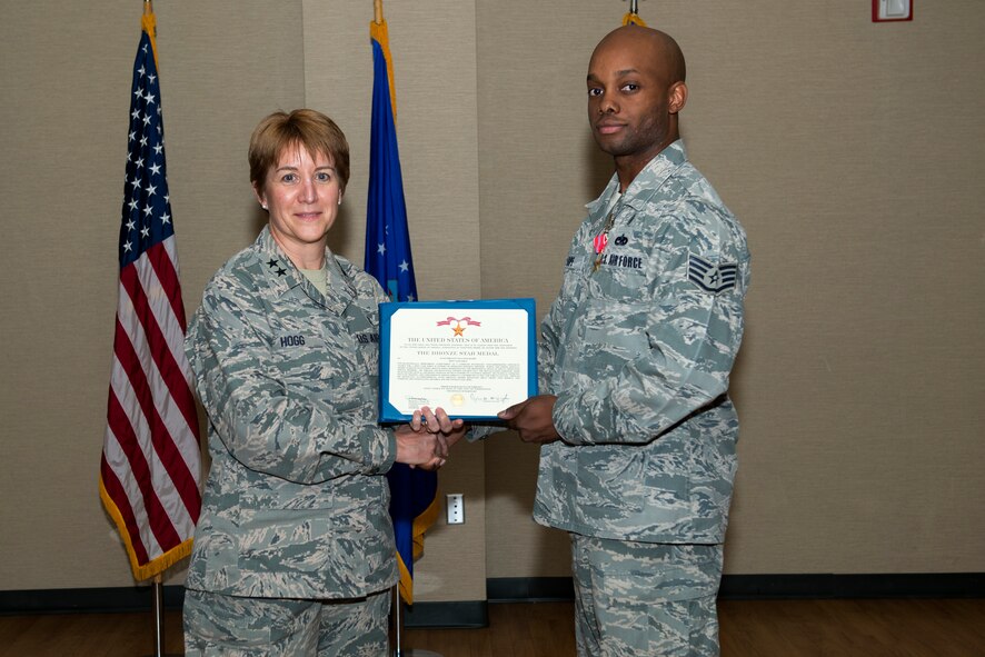 U.S. Air Force Staff Sgt. Malcolm J. Sharpe, 23d Medical Group NCO in charge of Alcohol and Drug Abuse Prevention and Treatment Program, receives a Bronze Star Medal from Maj. Gen. Dorothy A. Hogg, Assistant Air Force Surgeon General, Medical Force Development and Chief of the Nurse Corps, June 18, 2015, at Moody Air Force Base, Ga. Sharpe received the medal for his service during Operation Enduring Freedom. (U.S. Air Force photo By Airman 1st Class Kathleen D. Bryant/Released)