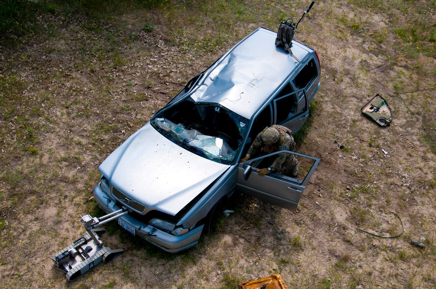 MSgt. Shawn Lundgren, 446th Civil Engineer Squadron explosive ordnance disposal technician, removes a simulated improvised explosive device after neutralizing it during the Patriot Warrior exercise at Fort McCoy, Wis., June 21, 2015. Patriot Warrior is a joint exercise designed to demonstrate contingency deployment training ranging from bare base buildup to full operational capabilities. It supports Exercise Global Lightning, a Combat Support Training Exercise (CSTX) including Global Medic 15 and Quartermaster Liquid Logistics Exercise 15 (QLLEX). Over 6,000 members from U.S. service components including Air Force, Army, and Navy (Active, Guard, and Reserve) participated alongside British and Canadian forces. (U.S. Air Force photo by Senior Airman Daniel Liddicoet/Released)
