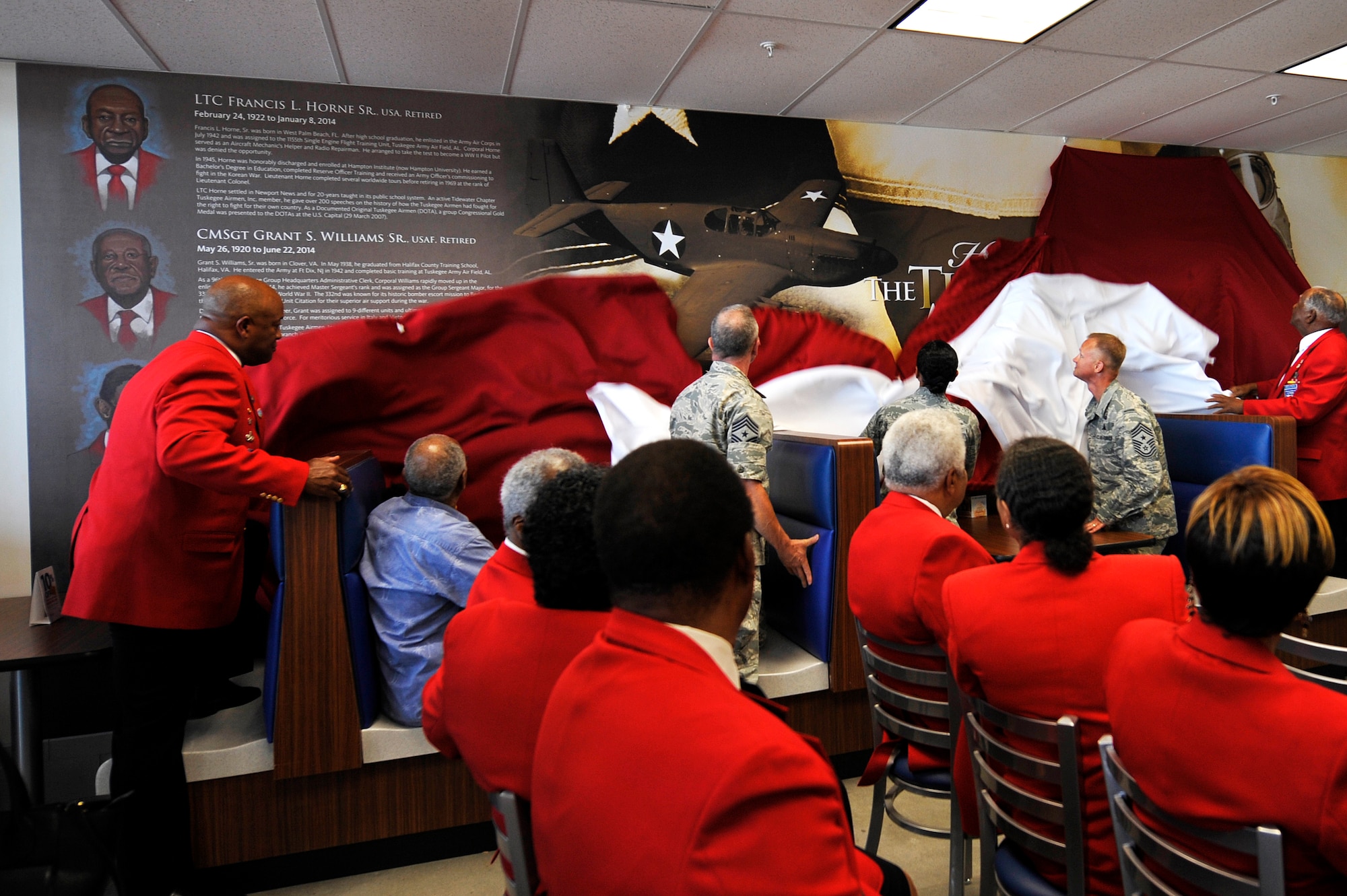 Tuskegee Airmen Inc. Tidewater Chapter members and base leadership unveil a mural dedicated to the Tuskegee Airmen at the Exchange at Langley Air Force Base, Va., June 18, 2015. (U.S. Air Force photo by Senior Airman Breonna Veal/Released)