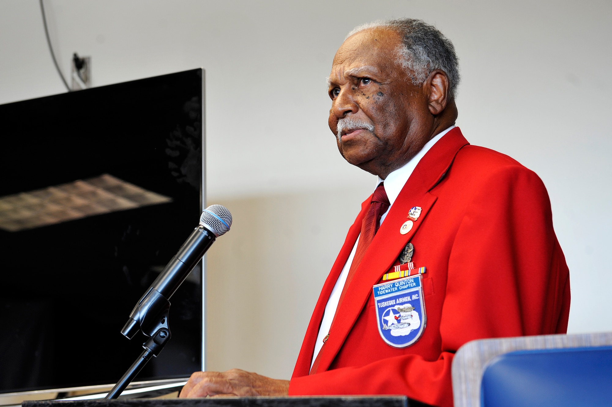 Harry Quinton, Tuskegee Airmen Inc. Tidewater Chapter member, speaks during the Tuskegee Airmen Mural unveiling at the Exchange at Langley Air Force Base, Va., June 18, 2015. As he reaches his 90th birthday, Quinton reminisces on flying as a Tuskegee Airman during World War II.  (U.S. Air Force photo by Senior Airman Breonna Veal/Released)
