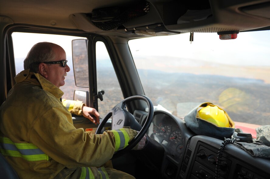 Mr. David Sunde, 9th Civil Engineer Squadron driver operator, drives a fire truck alongside a controlled burn at Beale Air Force Base, California on June 17, 2015. The burn consumed approximately 800 acres in an effort to renew cattle grazing land and control vegetation growth. (U.S. Air Force photo by Airman Preston L. Cherry) 
