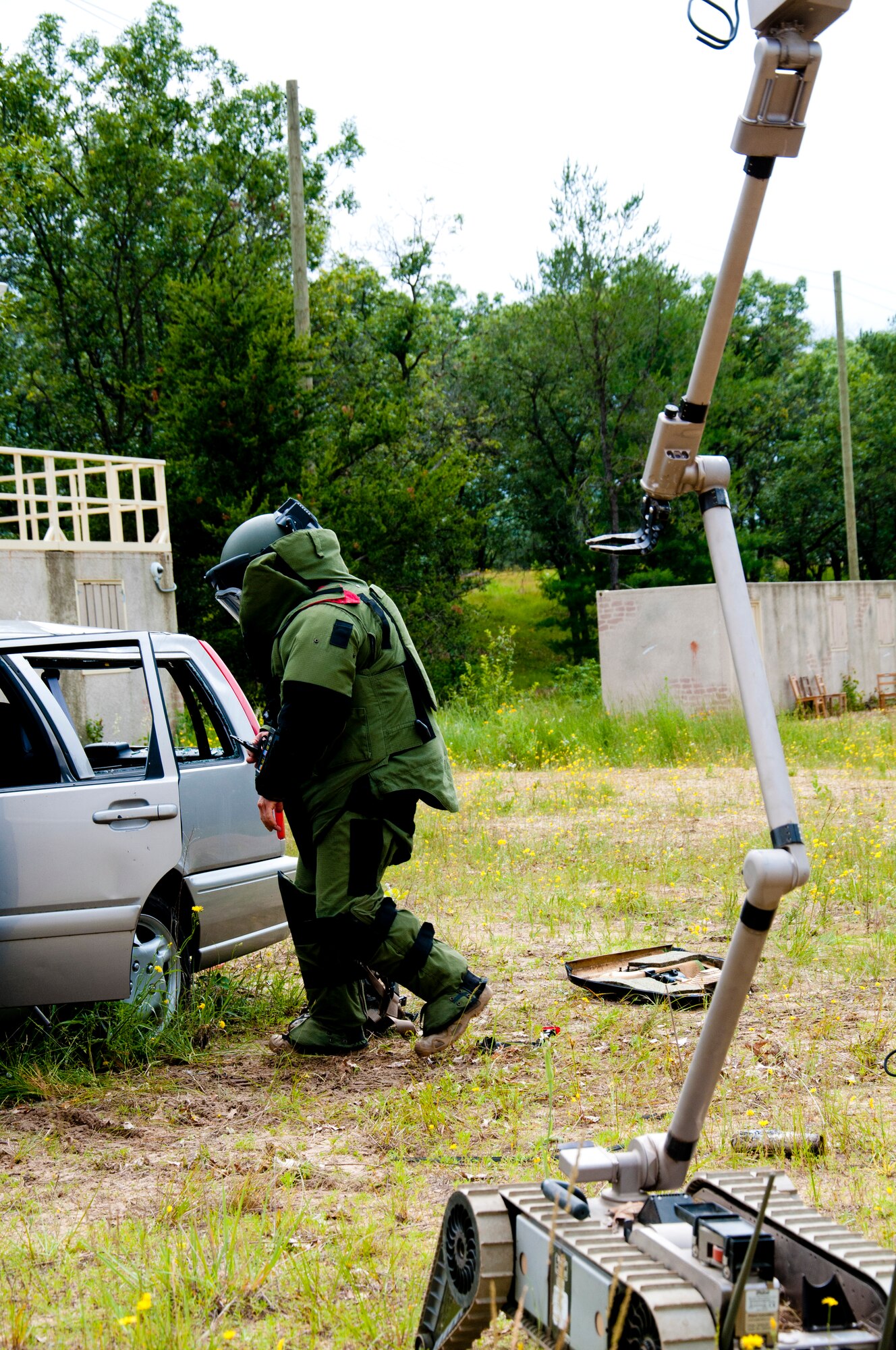 MSgt. Shawn Lundgren, 446th Civil Engineer Squadron explosive ordnance disposal technician approaches a car containing a simulated improvised explosive device in a bomb suit during the Patriot Warrior exercise at Fort McCoy, Wis., June 21, 2015. Patriot Warrior is a joint exercise designed to demonstrate contingency deployment training ranging from bare base buildup to full operational capabilities. It supports Exercise Global Lightning, a Combat Support Training Exercise (CSTX) including Global Medic 15 and Quartermaster Liquid Logistics Exercise 15 (QLLEX). Over 6,000 members from U.S. service components including Air Force, Army, and Navy (Active, Guard, and Reserve) participated alongside British and Canadian forces. (U.S. Air Force photo by Senior Airman Daniel Liddicoet/Released)