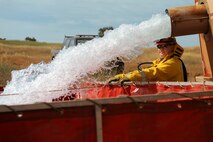 Staff Sgt. Vincent Kinard, 9th Civil Engineer Squadron firefighter, assists in filling a mobile water station for a controlled burn at Beale Air Force Base, California on June 17, 2015. The burn consumed approximately 800 acres in an effort to renew cattle grazing land and control vegetation growth. (U.S. Air Force photo by Preston L. Cherry)